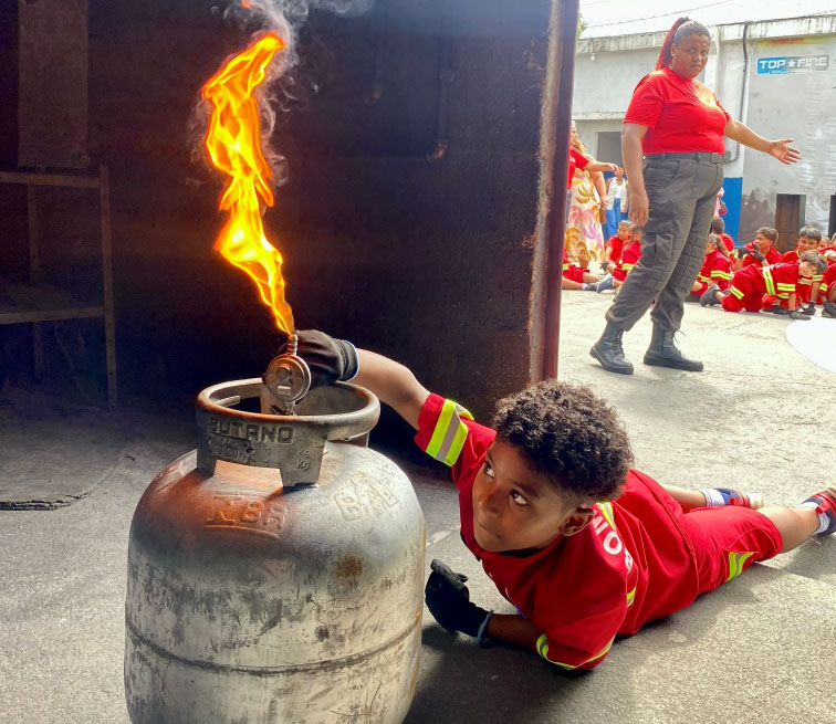 Aluno Oliver Kids aprendendo a apagar fogo em botijão de gás